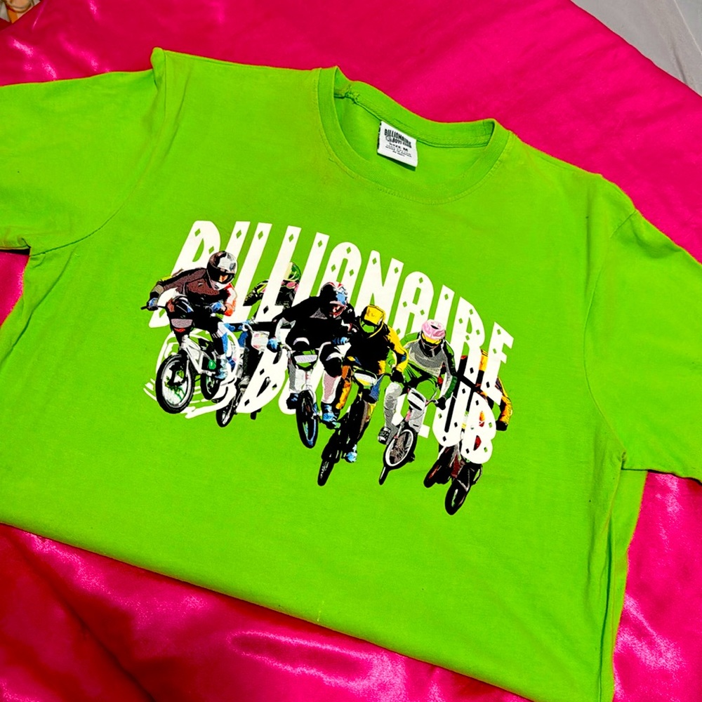 Neon green shirt with white writing and art for the background.